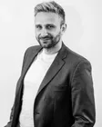 Rafał Moszkowcow (Chomsky), współzałożyciel SEODEV i CEO NON.agency, czarno-biały portret w marynarce