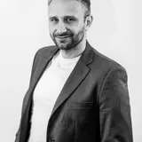 Rafał Moszkowcow (Chomsky), współzałożyciel SEODEV i CEO NON.agency, czarno-biały portret w marynarce